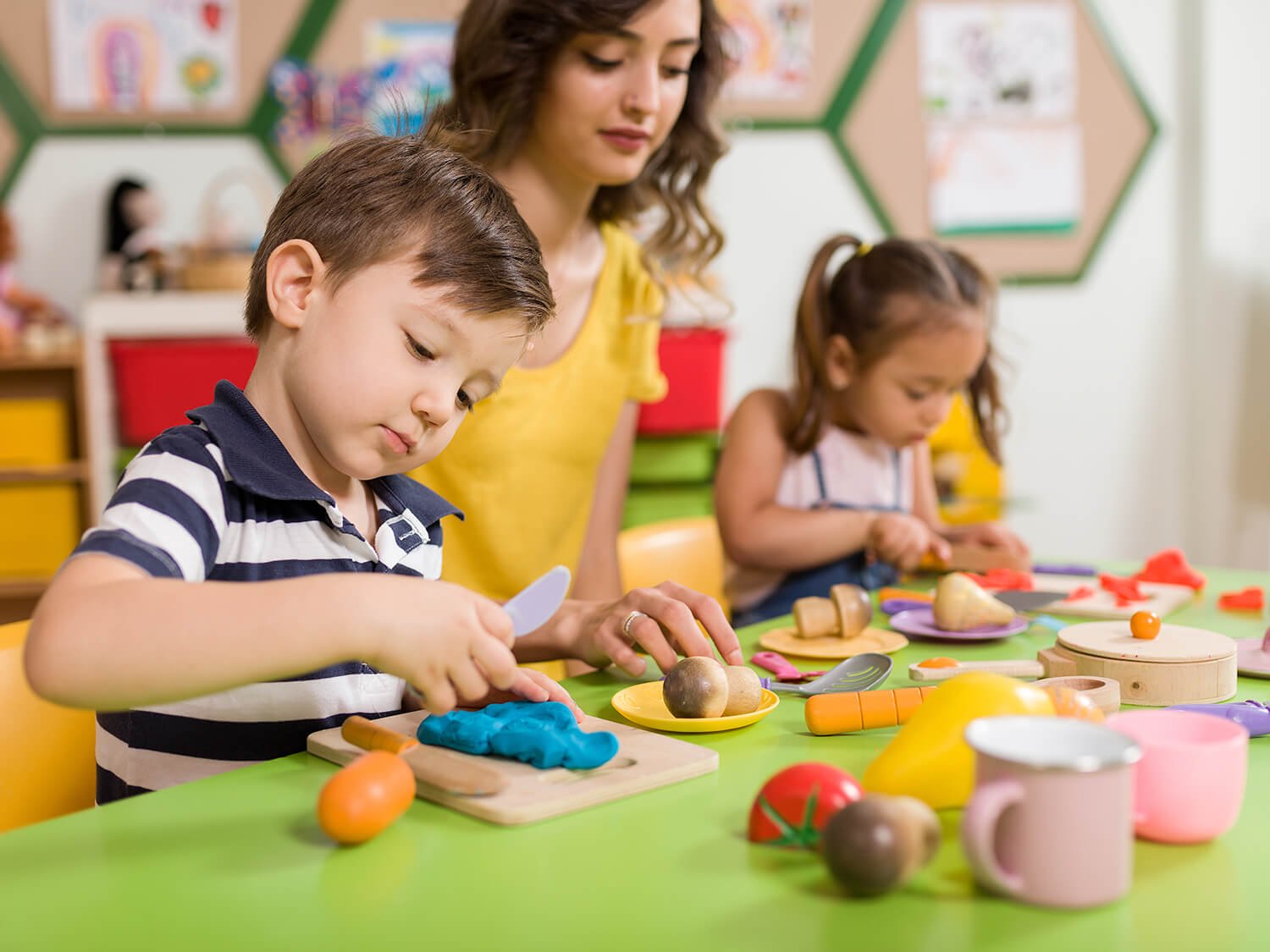 Children engaging in hands-on activities with a teacher in a Montessori-inspired classroom at Krityam Montessori School in Manyata Tech Park, Bengaluru.